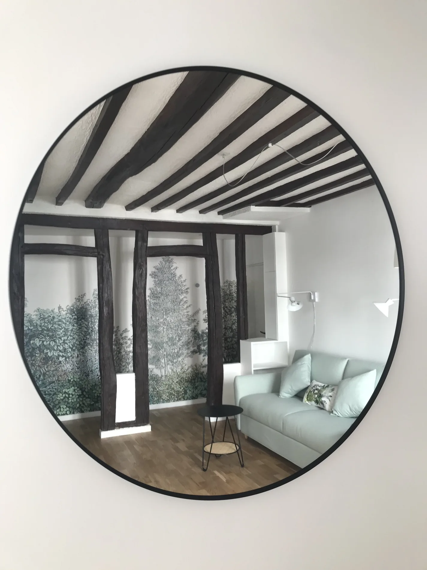 Miroir circulaire et reflet du séjour